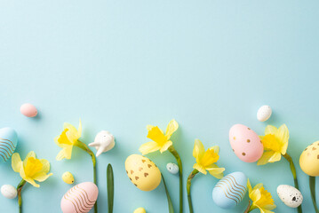 Wall Mural - festive composition featuring colorful easter eggs with daffodil flowers arranged on a soft blue bac