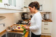 © Diego Martin/Stocksy - Middle age woman cutting Fresh Vegetables for Dinner