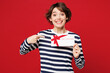 © ViDi Studio - Young surprised happy woman wear blue striped sweatshirt casual clothes hold point finger on gift certificate coupon voucher card for store isolated on plain red background studio. Lifestyle concept.