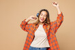 © ViDi Studio - Young smiling happy woman she wears orange shirt casual clothes listen to music in headphones raise up hands dance isolated on plain pastel light beige background studio portrait. Lifestyle concept.