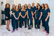 © VICTOR TORRES/Stocksy - Dedicated dental professionals posing in modern clinic setting