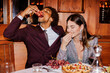 © BONNINSTUDIO/Stocksy - Elegant couple enjoying grapes and appetizers at restaurant table ugc