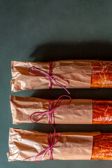 Traditional Hungarian Christmas cookies wrapped in craft paper, tied with ribbon on a green rustic background. Eco-friendly packaging. Zero waste