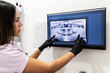 © Manu Prats/Stocksy - Dentist analyzes panoramic dental X-ray image
