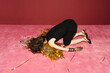 © Ulas&Merve/Stocksy - Woman Lying on Pink Carpet With Party Confetti and High Heels