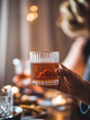 © Alexander Reitter - Elegant Celebration with Whiskey Glass Held by Woman in Festive Setting
