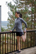 © Jovo Jovanovic/Stocksy - Woman doing warm-up exercise near railing