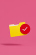 © Marc Tran/Stocksy - Yellow Folder With Red Check Mark on Pink Background