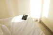 © Colour Laboratory/Stocksy - Modern smartphone device laying on a bed with soft beam of light