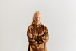 © Boris Jovanovic/Stocksy - Blonde woman wearing a brown blouse in studio