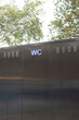 © Colour Laboratory/Stocksy - Silver metallic public toilet with neon light WC-sign in a urban city