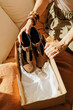 © BONNINSTUDIO/Stocksy - Woman unboxing stylish brown shoes at home