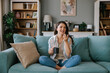 © Mihajlo Ckovric/Stocksy - Woman Relaxing on Sofa with Coffee and Smartphone at Home