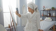 © Krakenimages.com - Woman taking a selfie in a spa wearing a bathrobe and towel on her head, capturing a moment of relaxation in a wellness center.