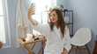 © Krakenimages.com - Woman taking a selfie in a modern bathroom wearing a white robe with candles and spa accessories on a wooden table
