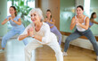 © JackF - Dynamic elderly woman attendee of dance studio doing aerobics during training session. Women training dance in hall
