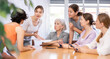 © JackF - Women of different ages examine documents while sitting at table in office