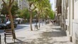 © Krakenimages.com - Outdoor scene with blurred trees and buildings along a sunny sidewalk in a city street with shadows