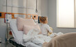 © Danil Nevsky/Stocksy - Little girl patient sitting on hospital bed looking out