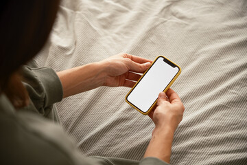 Anonymous woman using smartphone in bed
