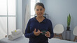 © Krakenimages.com - Young woman in a wellness center holding a product, standing in a serene spa room with chairs and towels in the background, highlighting the tranquil indoor setting for beauty treatments