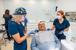 © VICTOR TORRES/Stocksy - Dental Team Treats Smiling Patient in Modern Clinic Setting