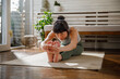 © Jovo Jovanovic/Stocksy - Fit young woman exercising on mat in living room