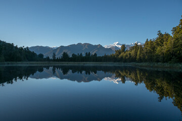 Wall Mural - Hiking through lush native bush pedestrian footpath around the lakeside of Lake Matheson