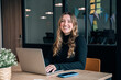 © Santi Nuñez/Stocksy - Smiling professional working on laptop in office