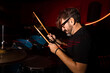© VICTOR TORRES/Stocksy - Intense drummer immersed in music under vibrant stage lights