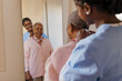 © BONNINSTUDIO/Stocksy - Caregiver helping elderly woman putting necklace in front of mirror