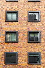 Wall Mural - details of brick residential building, with square windows, texture of the facade of residential area, architecture and design