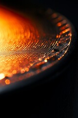 Poster - Close-up of a glowing, textured metallic surface with warm orange and dark hues.