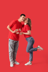 Poster - Young man greeting his beloved girlfriend with Valentine's day on red background