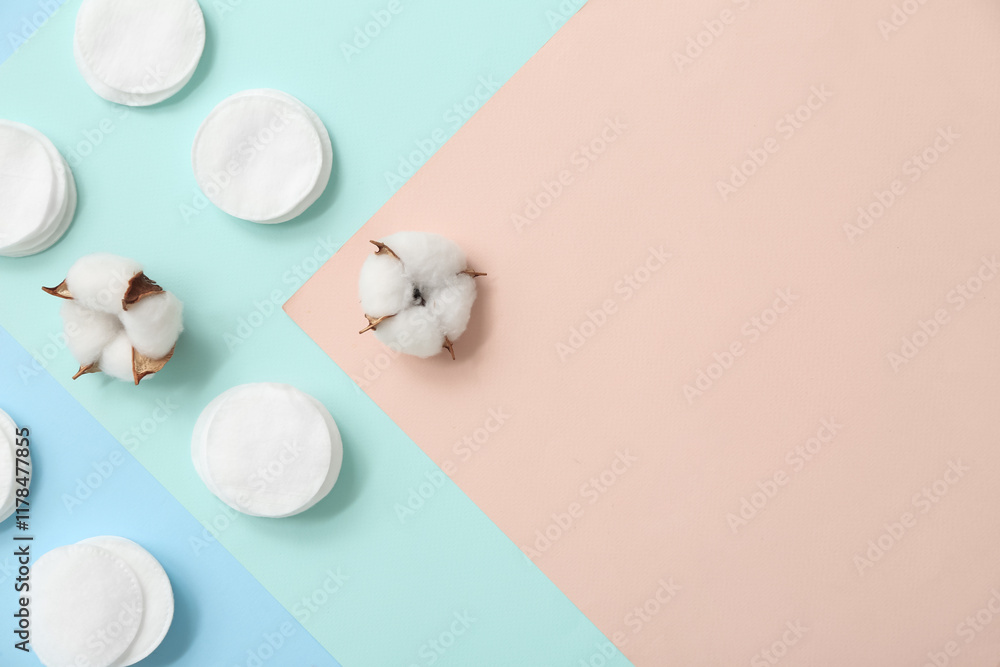 Composition with cosmetic pads and cotton flowers on color background