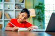 © StockImageFactory - Young Indian Boy Focused on Completing Homework, Sitting at Desk and Writing in a Copy at Home