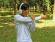 © Lailar Studio - sporty young asian male in sportswear stretching his arms. Sport activities concept