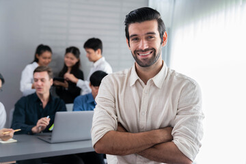 Aufkleber - Confidence and happy smiling businessman portrait with background of his colleague and business team working in office. Office worker teamwork and positive workplace concept. Prudent