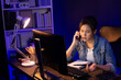 © Summit Art Creations - Young beautiful Asian creative woman calling on phone desk to customer or coworker explaining creator project's high profit while searching market analysis on pc at neon office at night. Stratagem.