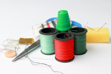 Travel Sewing Kit with Different Color Spools of Threads and Needles, Thimble and Buttons on white back ground