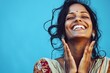 © radekcho - Indian woman with a joyful expression, smiling, beautiful and authentic portrait in casual attire against a blue background.