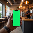 © malikpb - Smartphone with green screen in hand