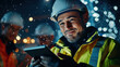 © kongkiat chairat - Group of civil engineers using digital tablet at night, smiling and focused on their work in construction site