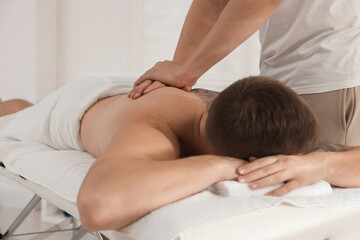 Wall Mural - Massage therapist working with patient in clinic, closeup