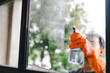 © Suphakant - people doing cleaning are using cloths and spraying disinfectant Wipe the glass in the office room. cleaning staff.cleaning maid