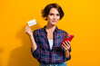 © deagreez - Photo of intelligent cheerful woman dressed checkered shirt hold smartphone credit card isolated on vibrant yellow color background