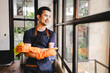 © Suphakant - male cleaning staff Hold wipes and a bottle of disinfectant spray. and cleaning equipment