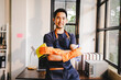© Suphakant - male cleaning staff Hold wipes and a bottle of disinfectant spray. and cleaning equipment