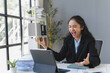 © amnaj - Asian businesswoman expressing excitement while looking at tablet in modern office, celebrating successful project or positive news
