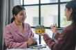 © amnaj - Two businesswomen engaging in a meeting, discussing strategies for a new house investment and navigating the real estate market